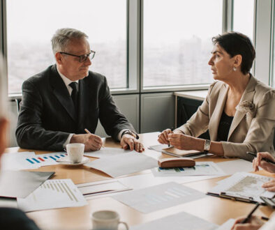 People, sitting around a table, conducting a meeting in Business English