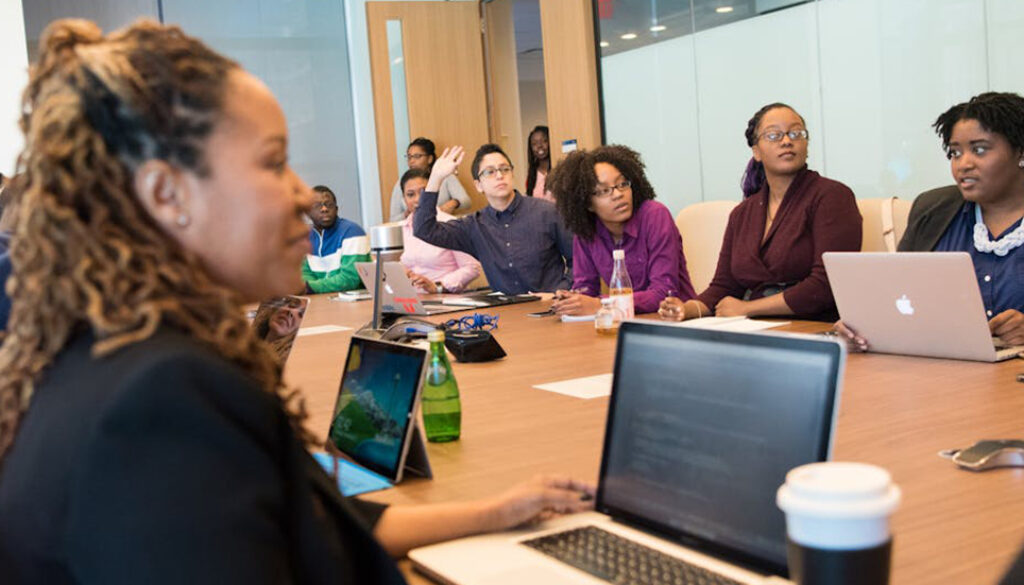 Group of adult learners, working on business English in an office session. Business English; language learning; learning a second language