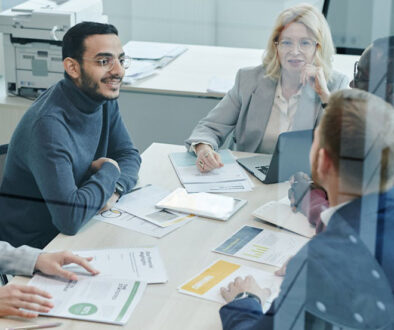 International group of office workers in a team meeting around a table. Euro English