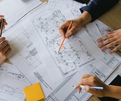 Technical Translation: How to Manage Technical Terminology. Photo shows a group of experts reviewing technical documents.