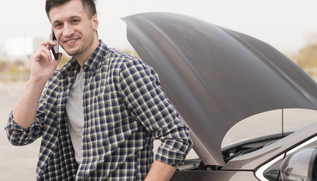 man-with-broken-car-talking-phone