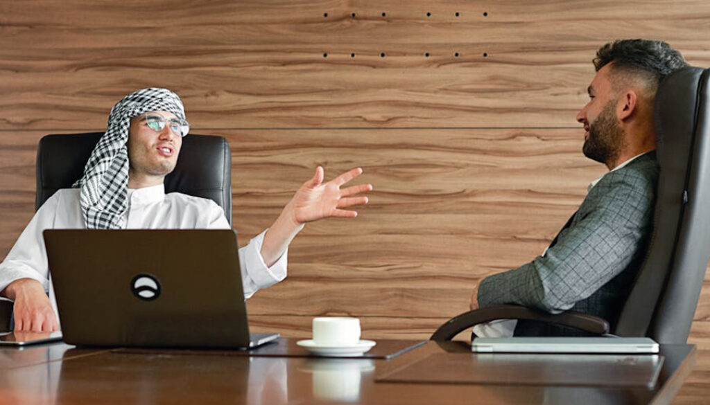 Two men, in an office environment, engaging in small talk in Business English.