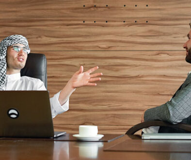 Two men, in an office environment, engaging in small talk in Business English.